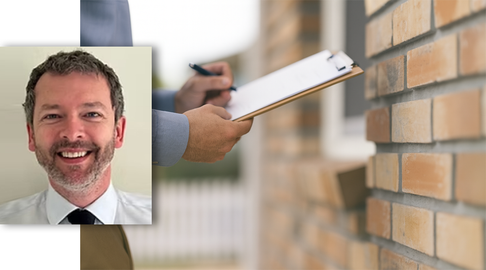 A surveyor holding a clipboard while inspecting a brick wall structure.