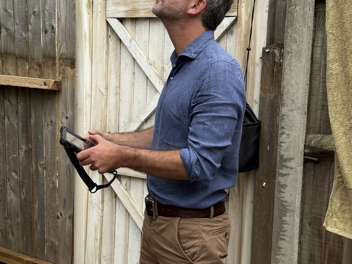 Surveyor preparing drone equipment before an aerial roof inspection