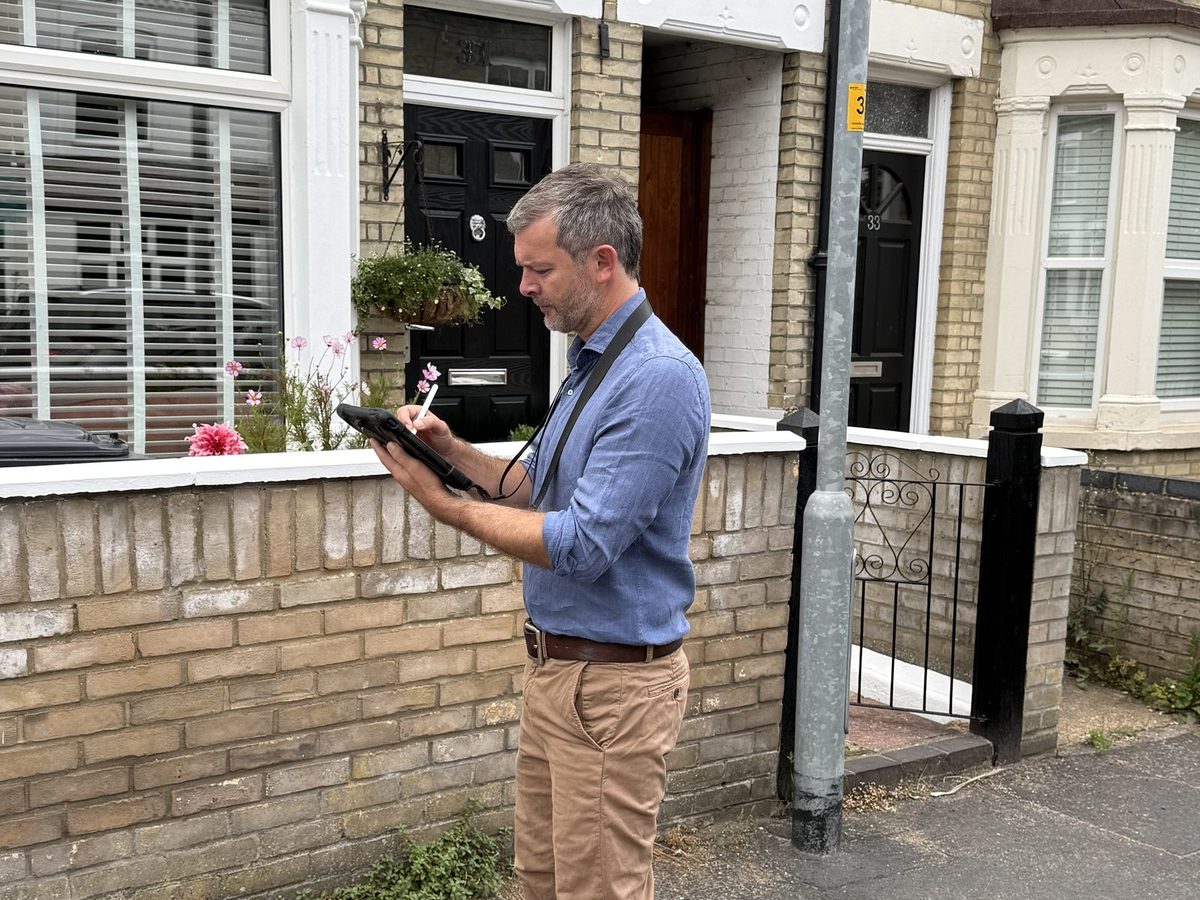 Surveyor carrying out a Level 2 homebuyer survey inspection of a terraced property